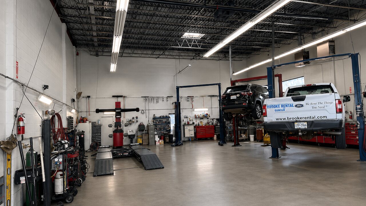 The PT Auto Experts service bay, with vehicles on two-post lifts and an alignment rack along the wall