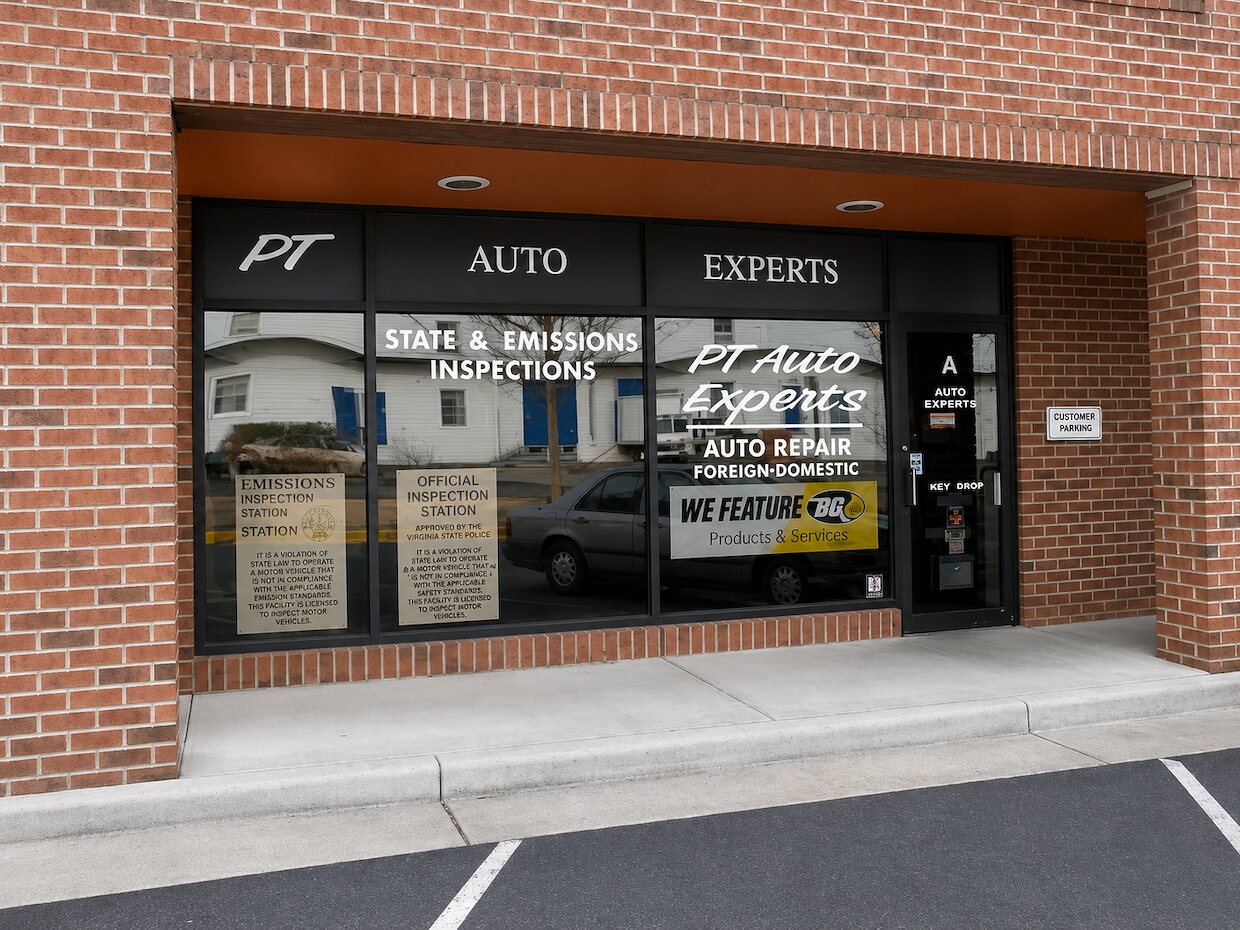 The PT Auto Experts storefront in Suite A, with State and Emissions Inspections lettered on the window