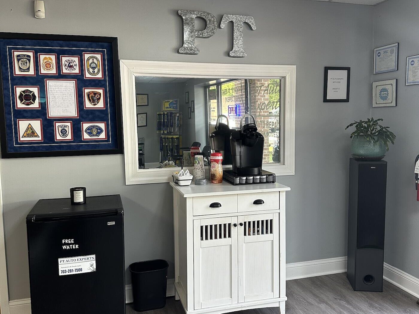 The PT Auto Experts front office, with free coffee, bottled water, and framed certificates on the wall